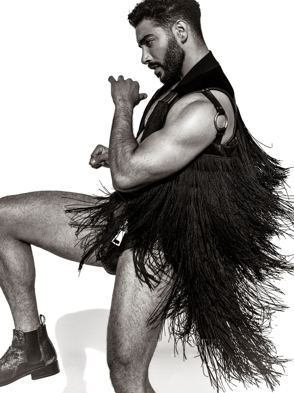 Menswear editorial: a leather harness and long feather skirt, black and white