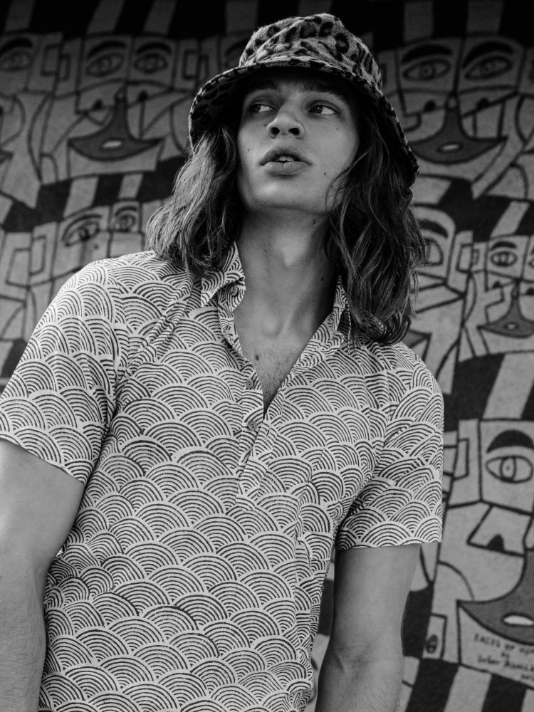Strange Memories for JÓN Magazine: a wave-print polo and leopard bucket hat against a painted mural, styled by Quentin Fears