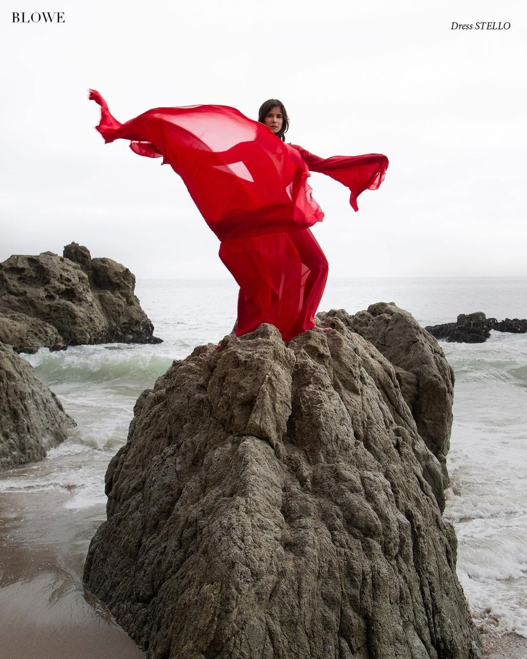 Actress Patricia Velásquez in a red silk chiffon Stello gown on an ocean rock for BLOWE Magazine, styled by Quentin Fears