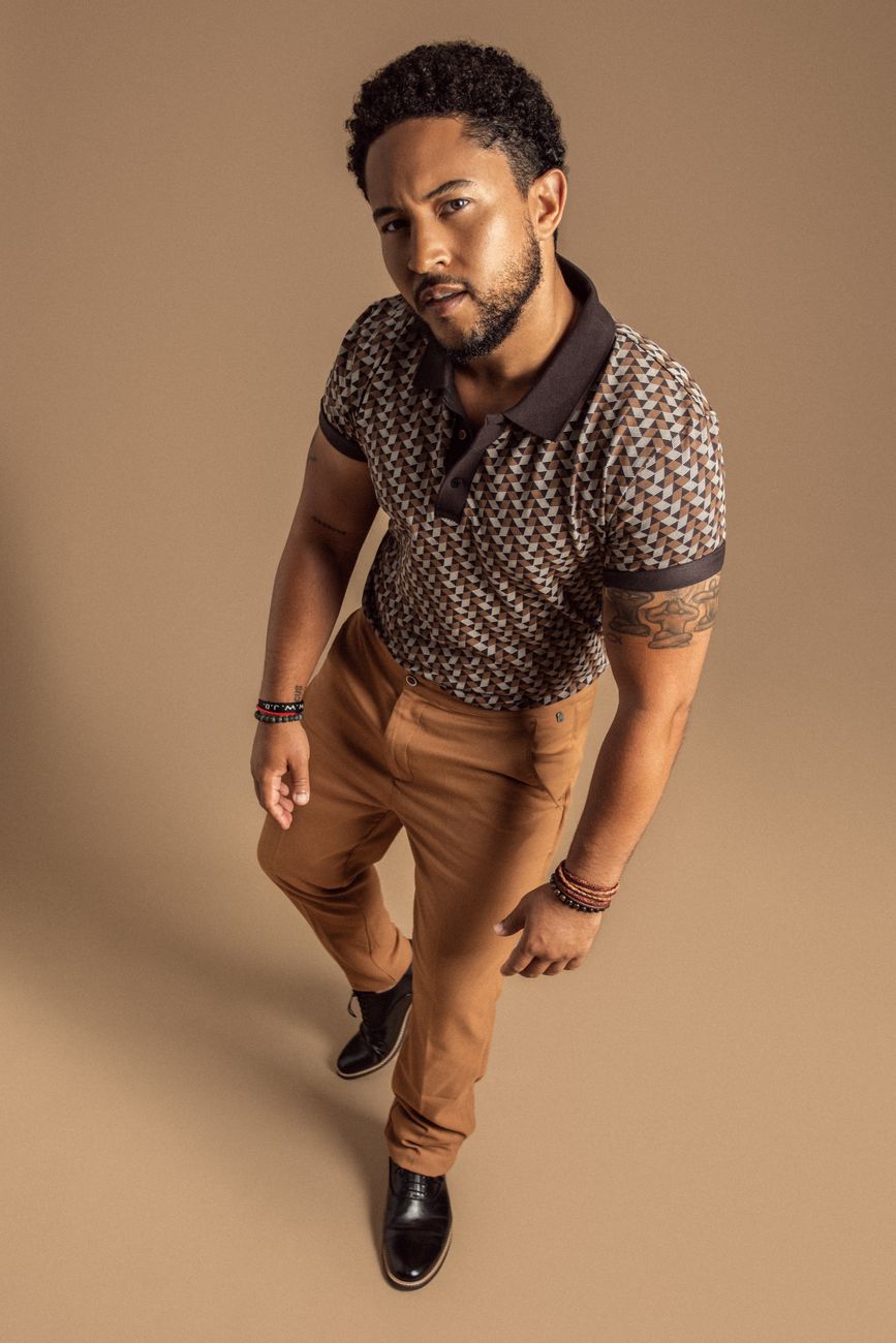 Actor Tahj Mowry in a patterned knit polo and tailored camel trousers, styled by Quentin Fears