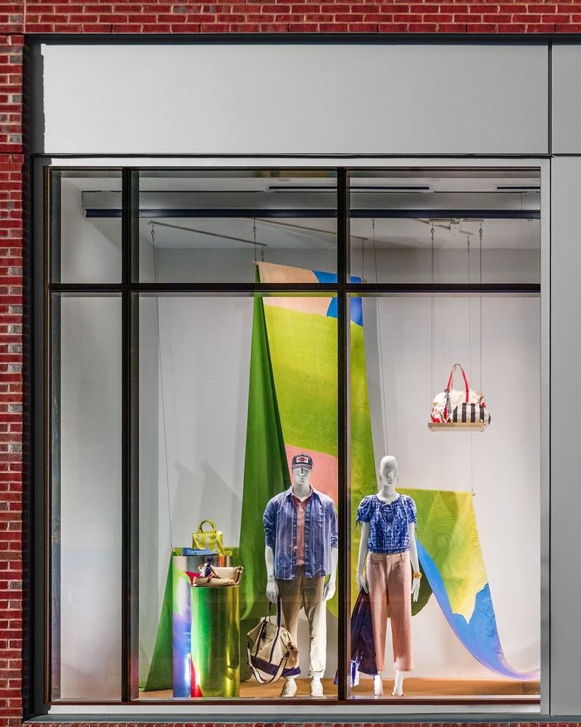 Spring Awakening, a Walmart Fashion Statement Window in Bentonville, with artist Muoi Le's painted canvases hanging behind the spring looks